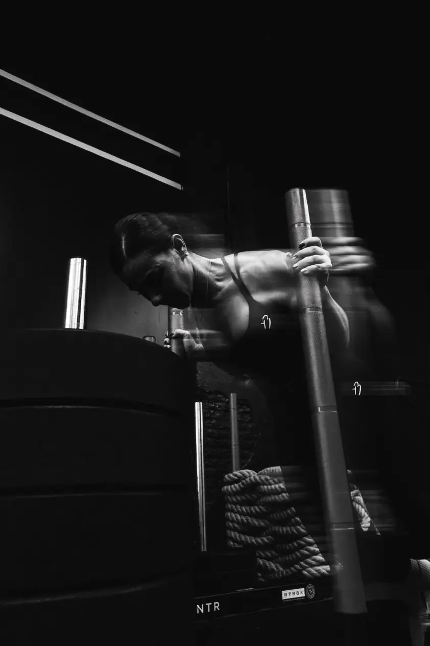Une femme saisit une barre, en salle, en noir et blanc