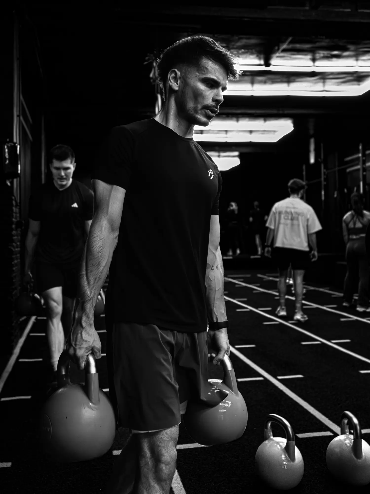 Deux kettlebells en main, la marche du farmer carry