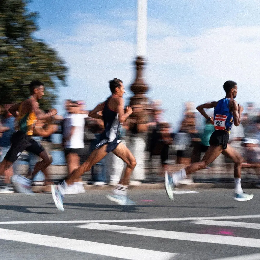 Des coureurs lancés sur une route de course urbaine, flou de mouvement